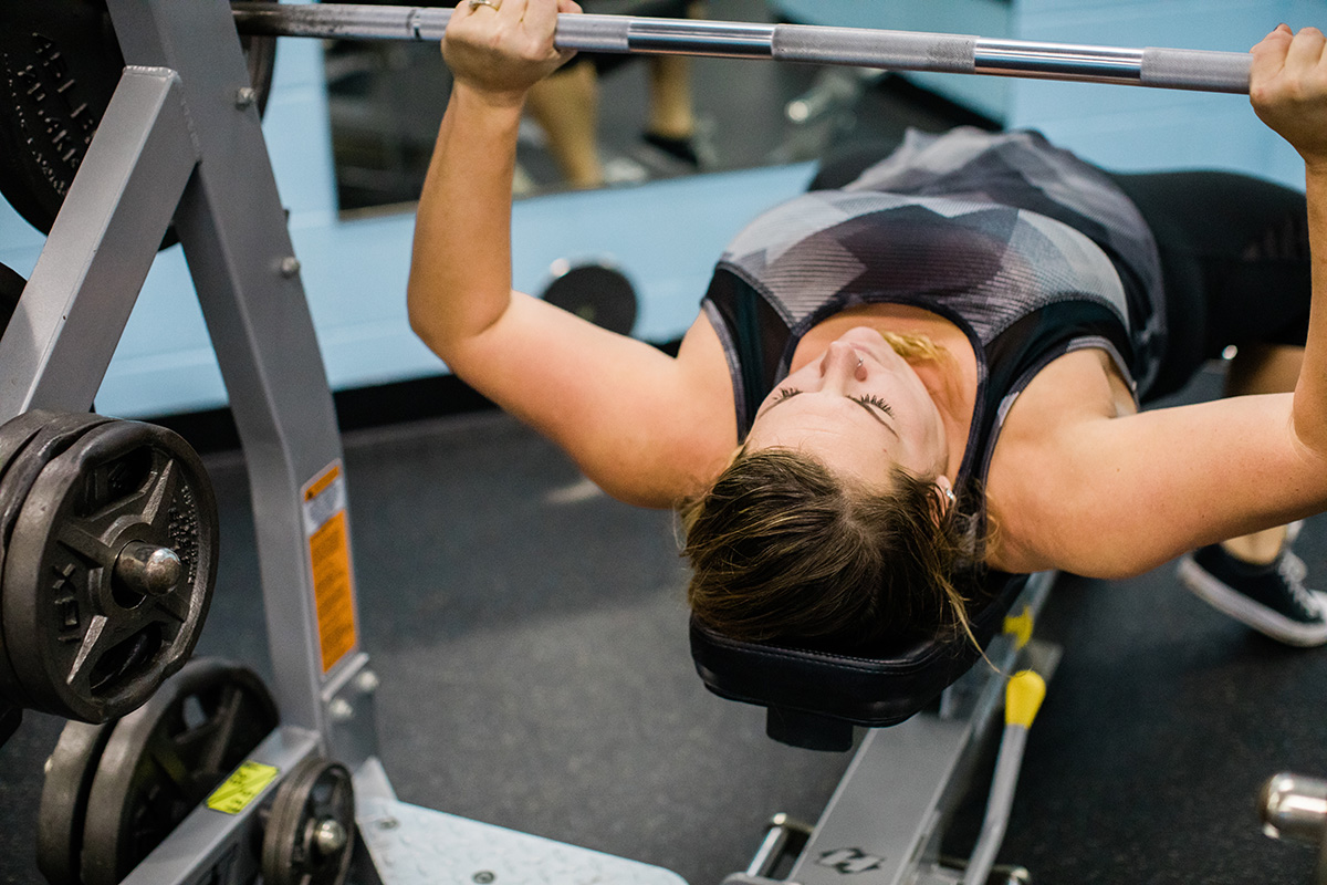 Woman bench presses 