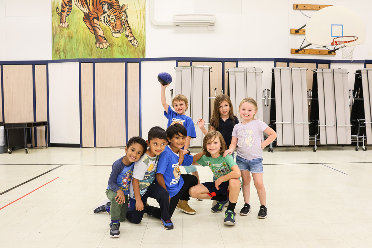 A small group of students smiling in a school cafeteria