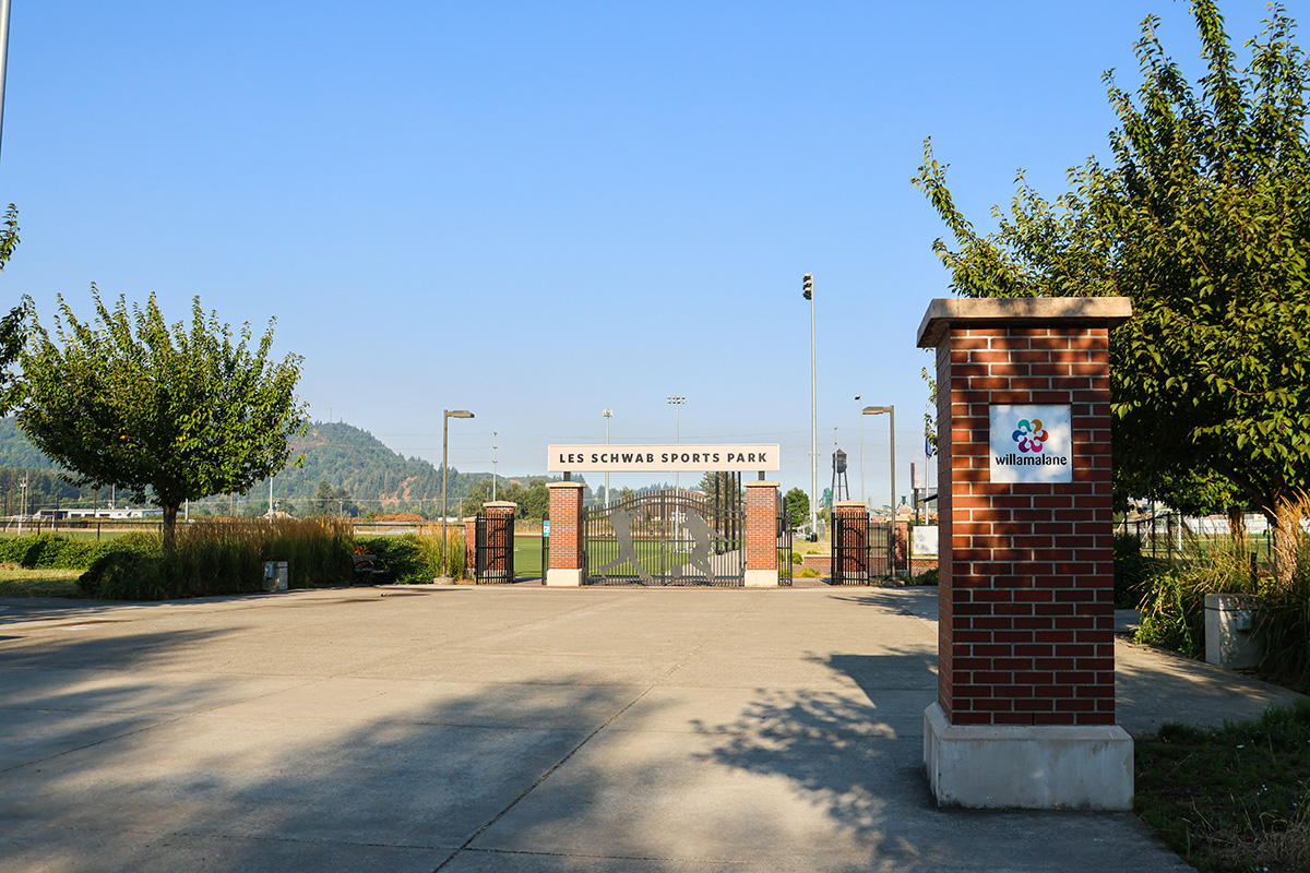 Entry of Les Schwab Sports Park showing large field gates and paved area