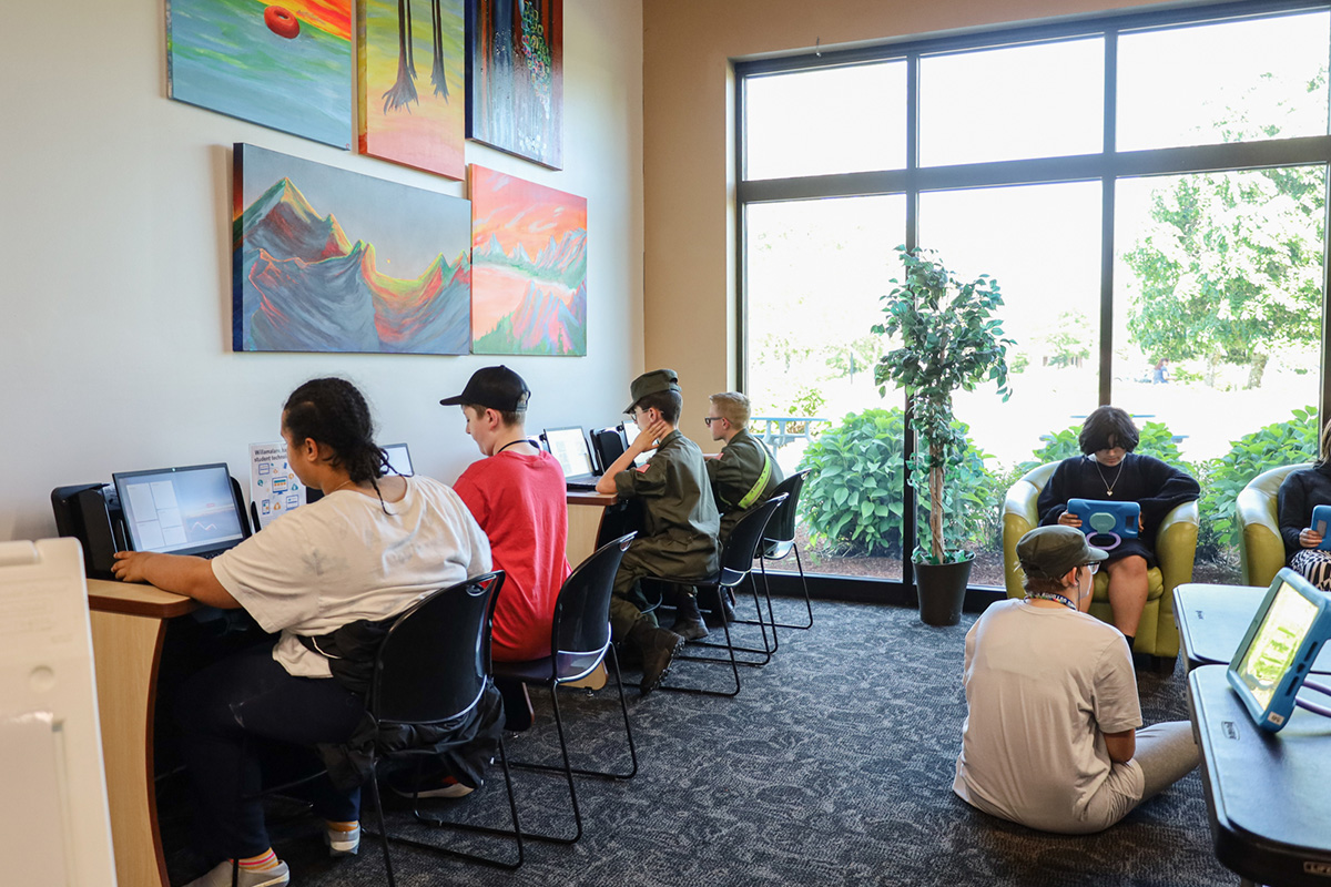 Middle school students using laptops and tablets