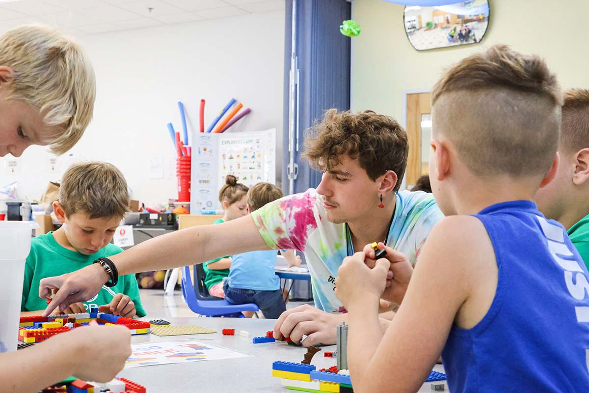 Willamalane staff member helps students build legos at summer camp