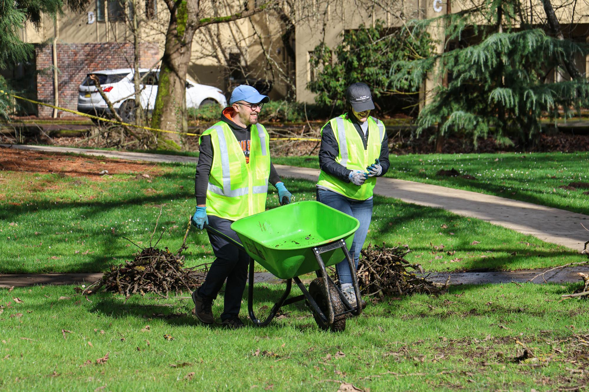 Two volunteers moving a wheelbarrow