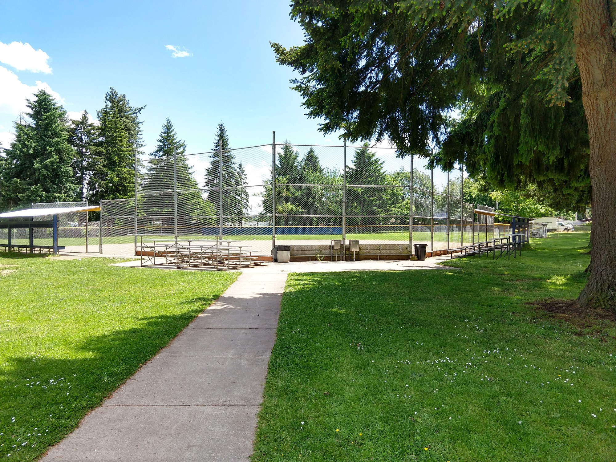 paved walkway leading up to a ball field at James Park in summer