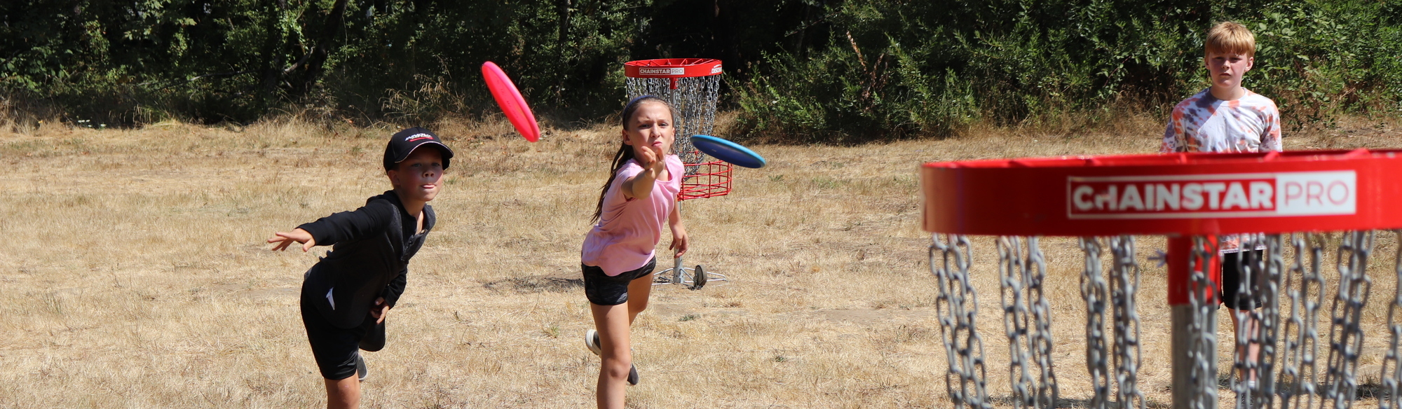 Two kids play disc golf