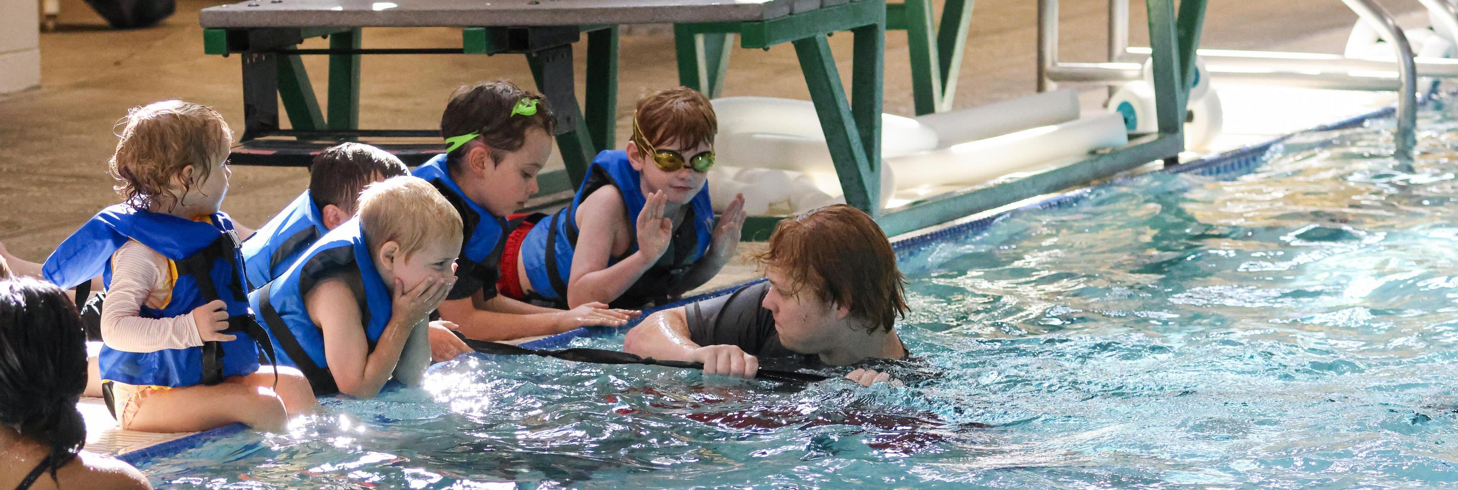 Preschoolers learn to swim with teacher