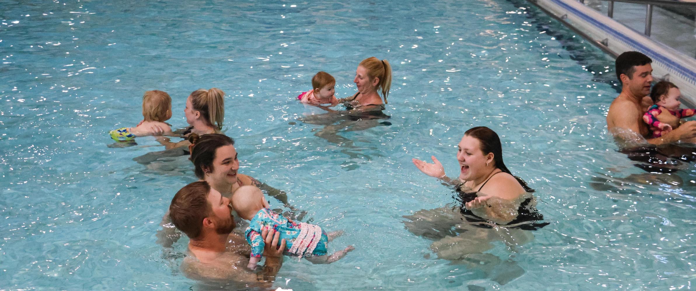 Babies in pool with parents during swim lessons