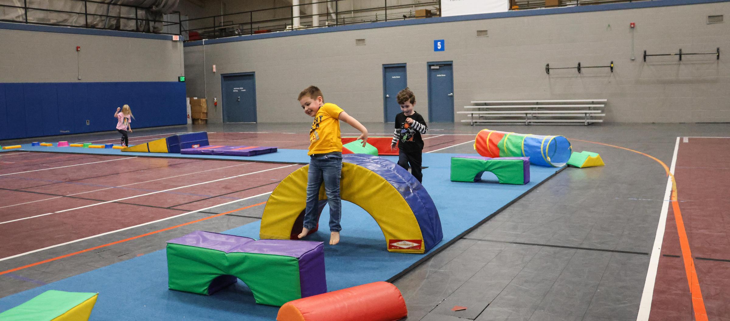 Kids complete obstacle course with foam blocks indoors 