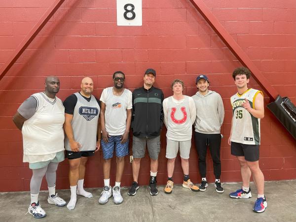 Seven men pose in the gym