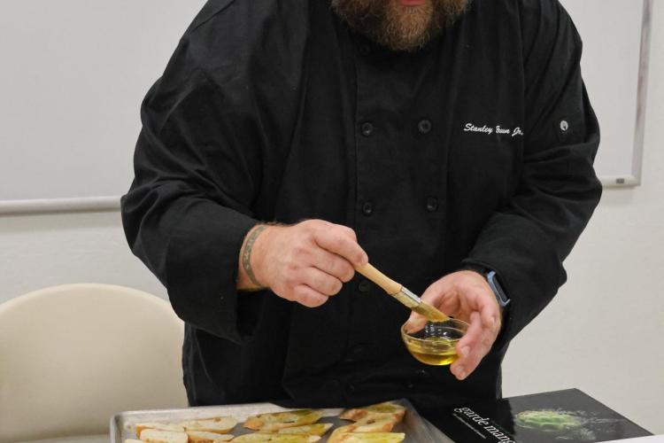 a chef spreading oil on bread