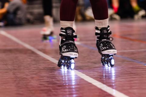 A pair of black and white skates glides along the floor.