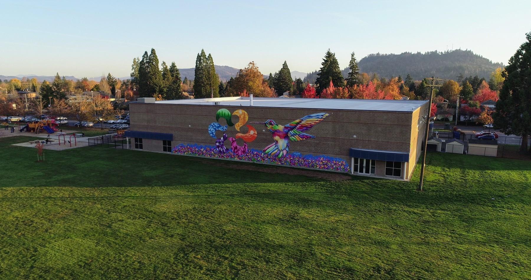Drone image of the large mural on the side of Willamalane Park Swim Center