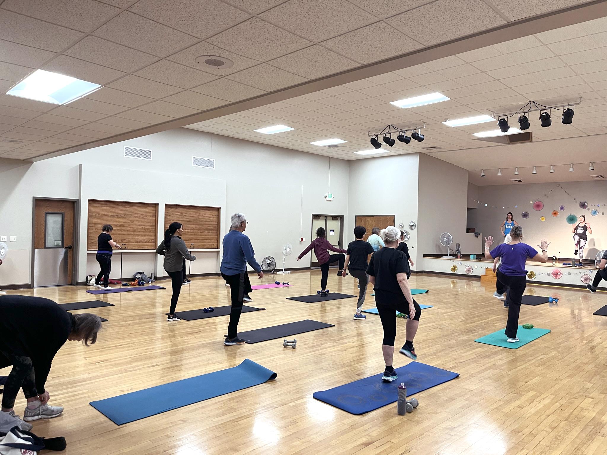 A group of adults stand in a fitness class.