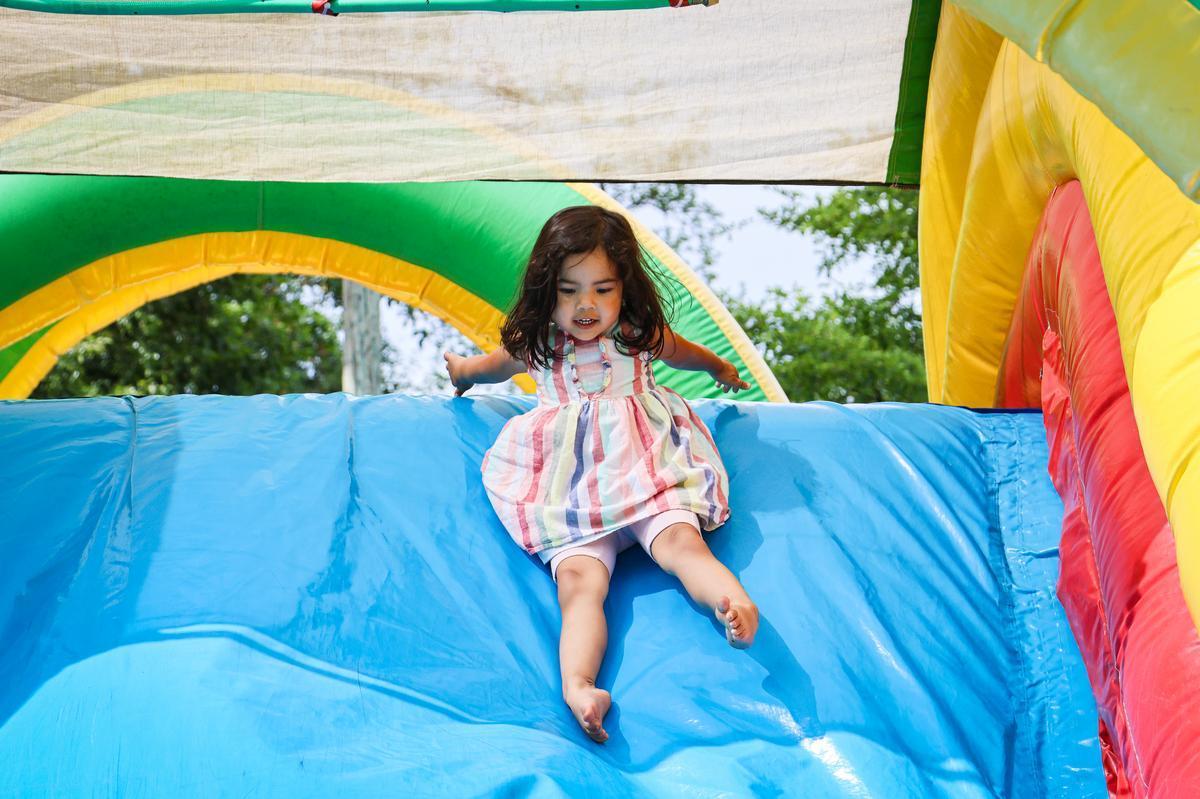 Child slides on inflatable play structure at Children's Celebration