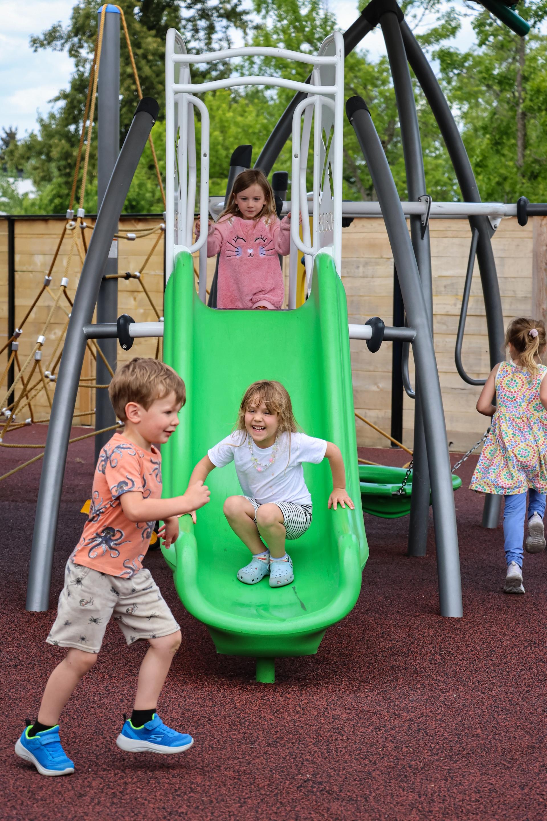 Children play on an outdoor slide.