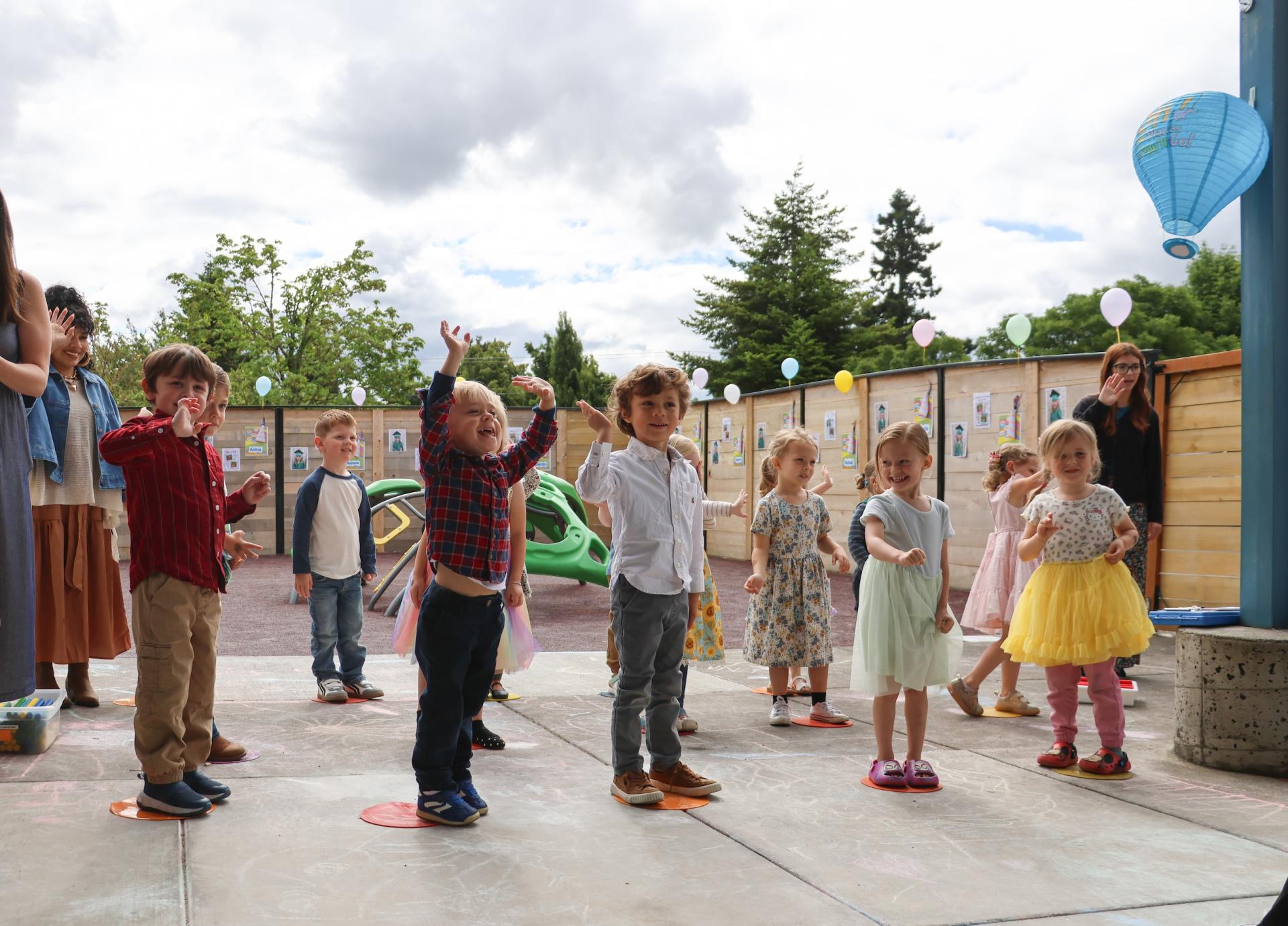 A group of preschoolers do an activity at the outdoor playground.
