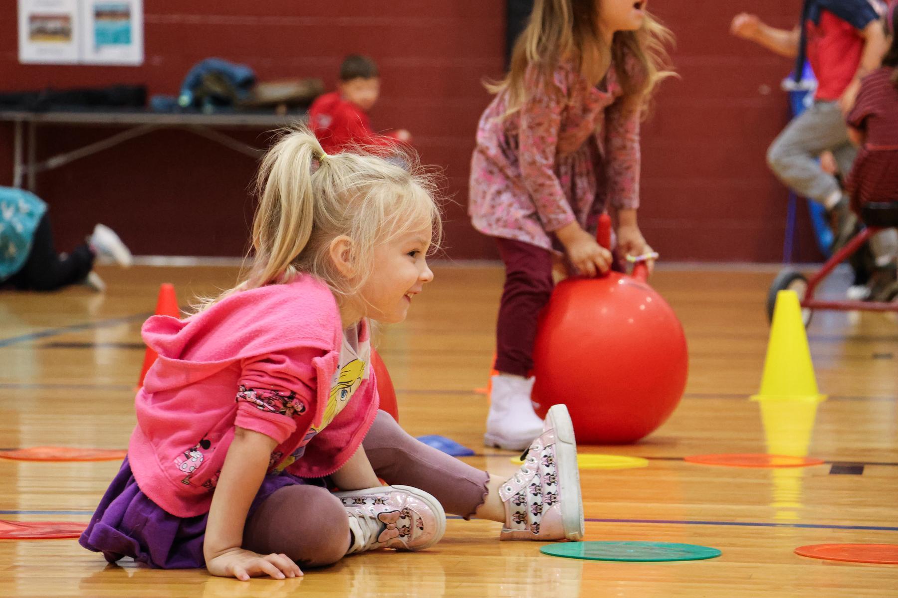 Child stretches on indoor wood courts 