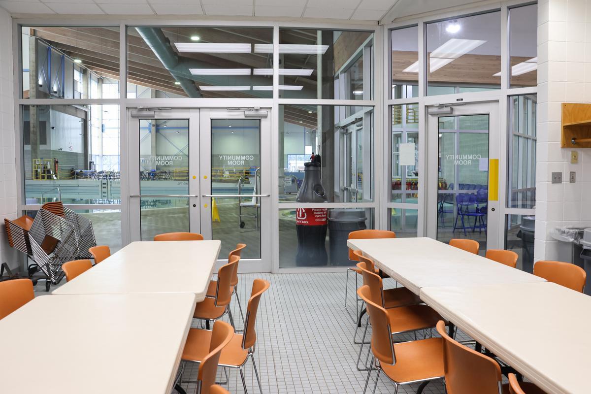 A community room hosts sets of tables and chairs