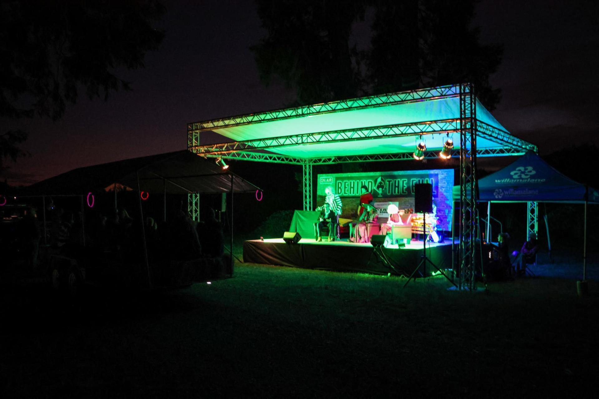 a lit up stage in the dark orchards of Dorris Ranch