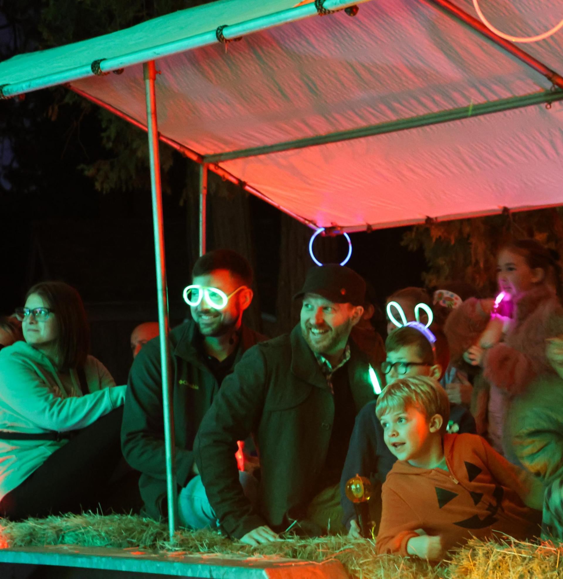People sitting on the hayride trailer smiling