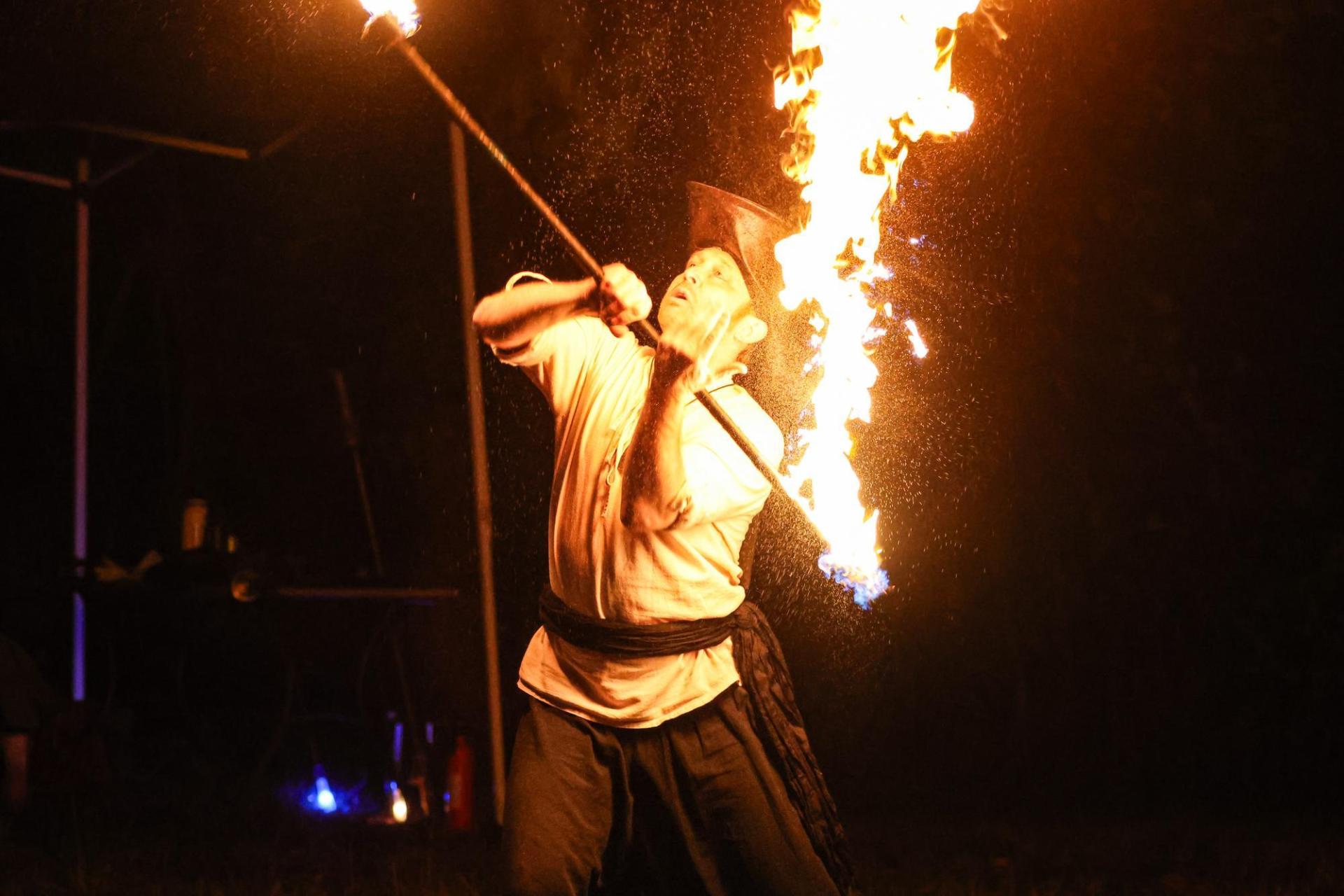 a fire performer handles fire in the dark