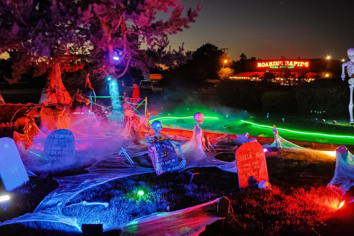 A mini golf course at night with colorful lights and decorations.