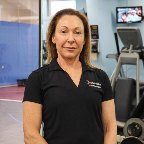 woman looking at the camera standing in the fitness center