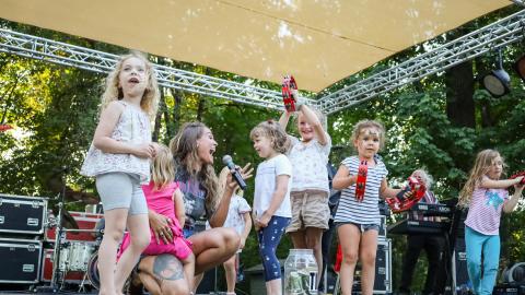 Band member sings to children on stage
