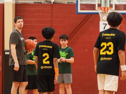 Students play basketball in branded jerseys